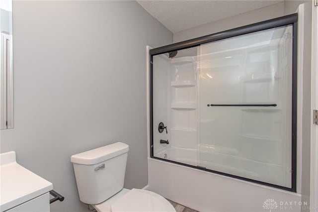 bathroom with shower / bath combination with glass door, a textured ceiling, vanity, and toilet