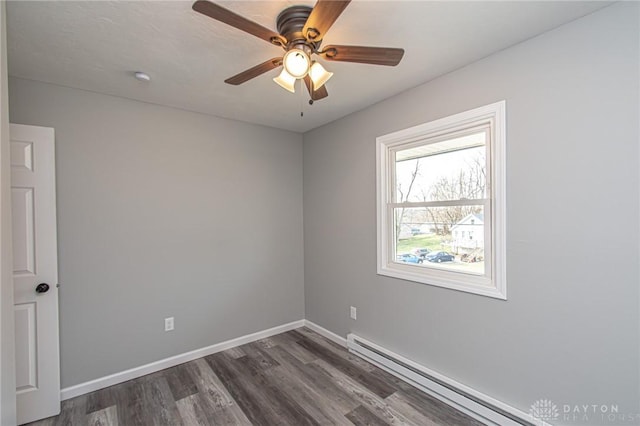 spare room featuring a ceiling fan, dark wood-style floors, baseboards, and baseboard heating