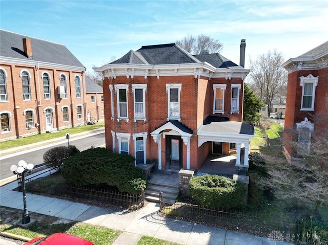 italianate-style house with brick siding and a chimney