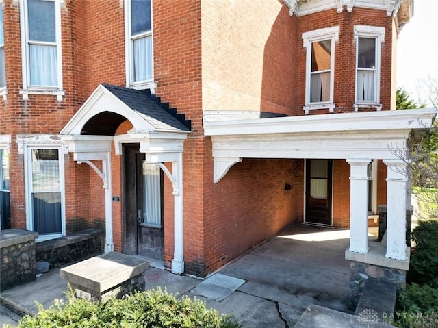 entrance to property featuring brick siding