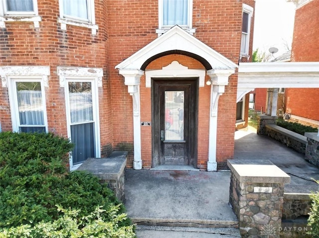 view of exterior entry with brick siding