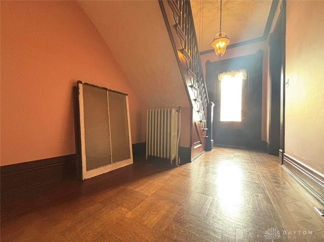 foyer entrance with tile patterned floors, radiator heating unit, and lofted ceiling