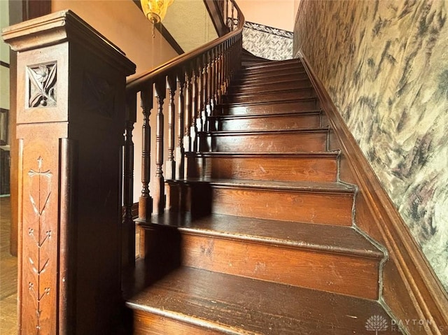 staircase with wallpapered walls