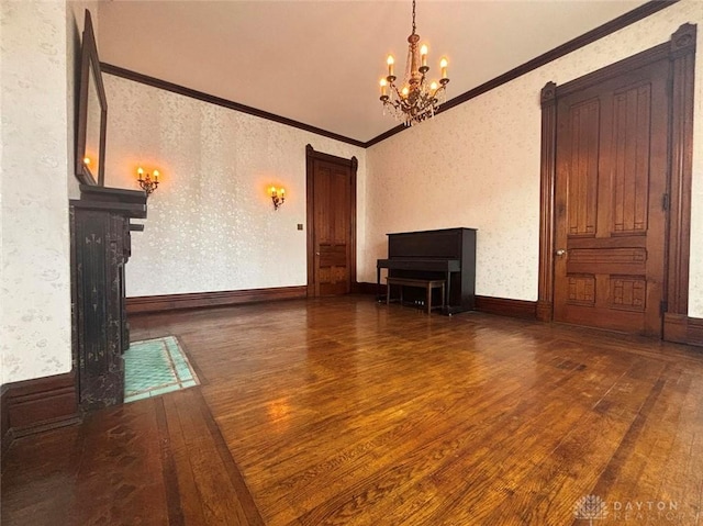 unfurnished living room featuring a chandelier, wallpapered walls, and hardwood / wood-style floors