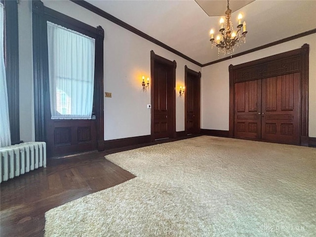 entryway featuring crown molding, radiator heating unit, baseboards, and a chandelier