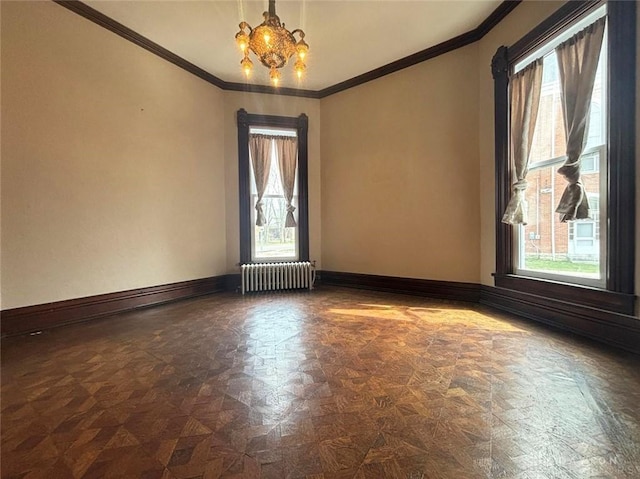 unfurnished room featuring a notable chandelier, radiator, baseboards, and a wealth of natural light