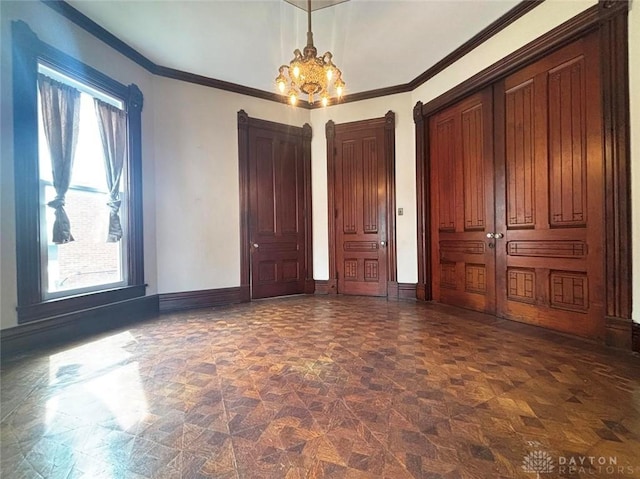 unfurnished bedroom featuring baseboards, multiple windows, and a chandelier