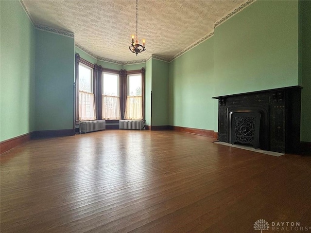 unfurnished living room featuring radiator, wood finished floors, and a chandelier