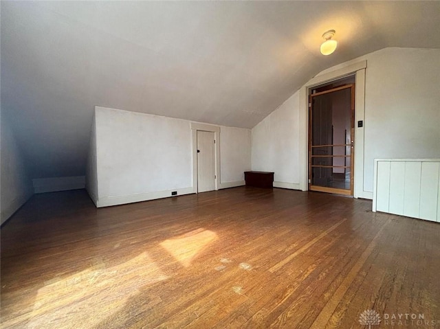 additional living space featuring vaulted ceiling and hardwood / wood-style flooring