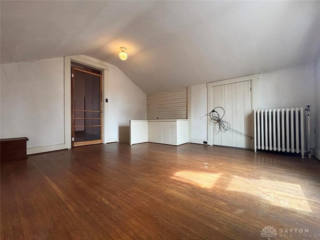 bonus room featuring lofted ceiling, radiator, and hardwood / wood-style flooring