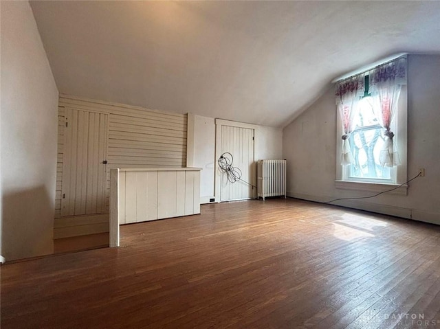 additional living space featuring lofted ceiling, wood finished floors, and radiator heating unit
