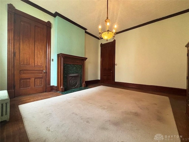 unfurnished living room featuring baseboards, a fireplace with flush hearth, ornamental molding, an inviting chandelier, and a textured ceiling