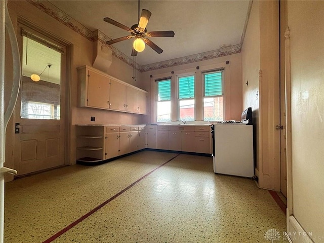 kitchen featuring light floors, ornamental molding, ceiling fan, light countertops, and range