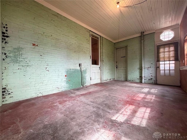 unfurnished room with brick wall