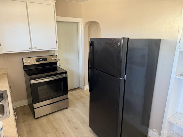 2 County Line Rd, College Corner, OH 45003 - kitchen with light wood finished floors, light countertops, freestanding refrigerator, electric range, and white cabinets