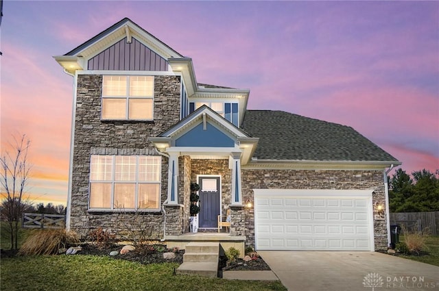 view of front of home featuring stone siding, driveway, an attached garage, and fence