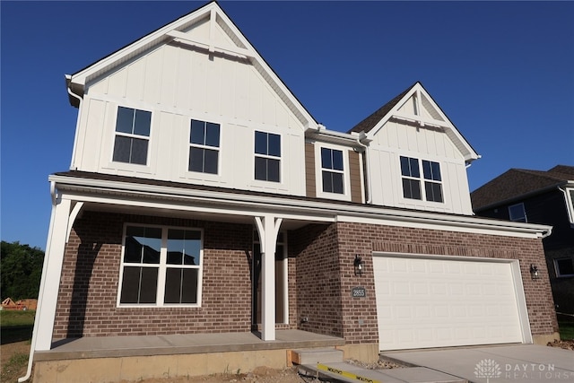 2855 Sky Crossing Dr Unit 50, Beavercreek, OH 45434 - view of front of home featuring a porch, board and batten siding, a garage, brick siding, and concrete driveway