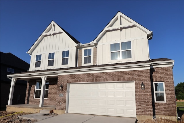 2855 Sky Crossing Dr Unit 50, Beavercreek, OH 45434 - view of front of property featuring covered porch, a garage, brick siding, and board and batten siding