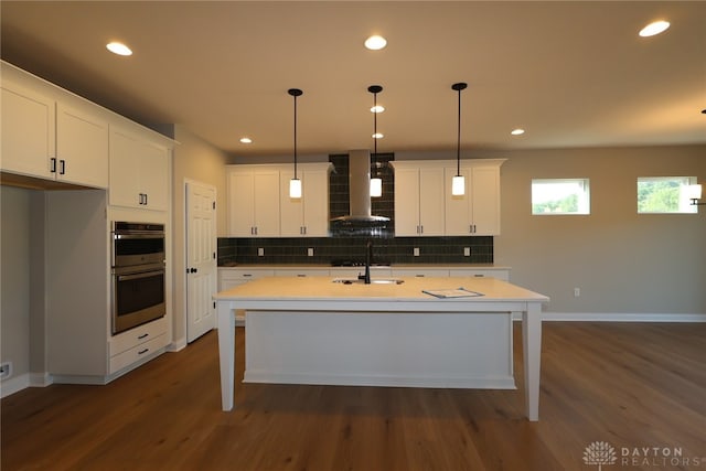 2855 Sky Crossing Dr Unit 50, Beavercreek, OH 45434 - kitchen featuring wall chimney range hood, double oven, decorative backsplash, dark wood-style flooring, and recessed lighting