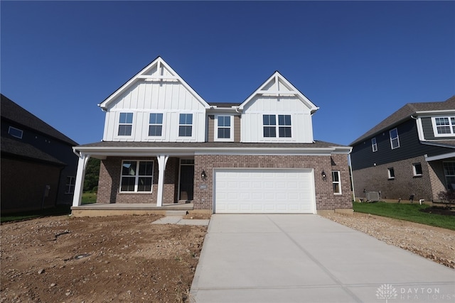 2855 Sky Crossing Dr Unit 50, Beavercreek, OH 45434 - view of front of home with a porch, board and batten siding, an attached garage, driveway, and brick siding