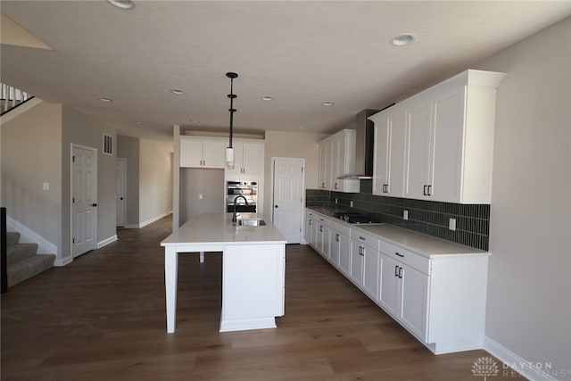 2855 Sky Crossing Dr Unit 50, Beavercreek, OH 45434 - kitchen featuring wall chimney exhaust hood, black stovetop, backsplash, white cabinetry, and an island with sink