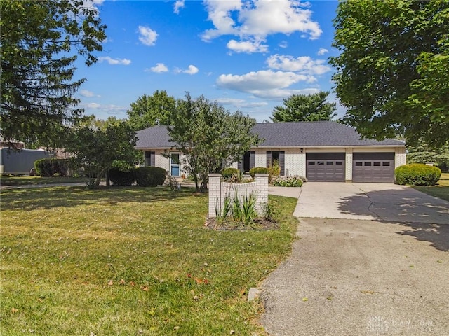 view of front of house featuring an attached garage, a front lawn, and driveway