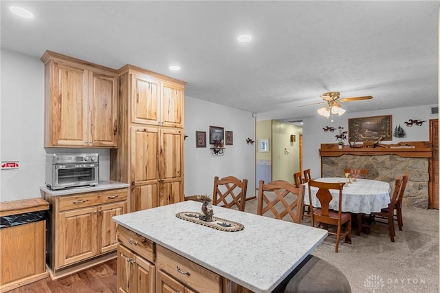 kitchen featuring light countertops, a center island, a ceiling fan, recessed lighting, and a toaster