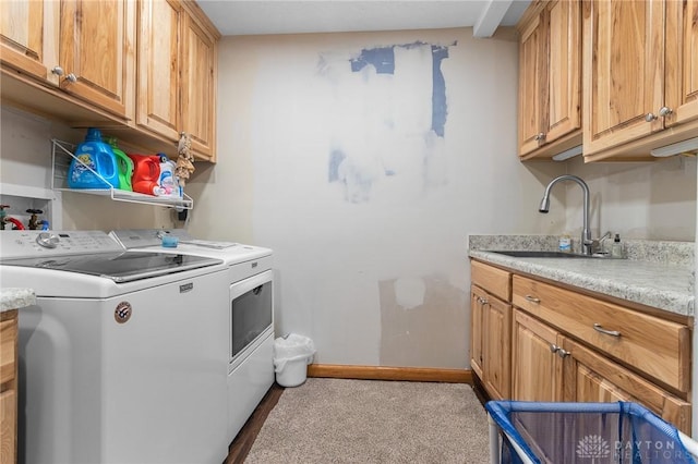 laundry area featuring cabinet space, baseboards, washing machine and dryer, and a sink