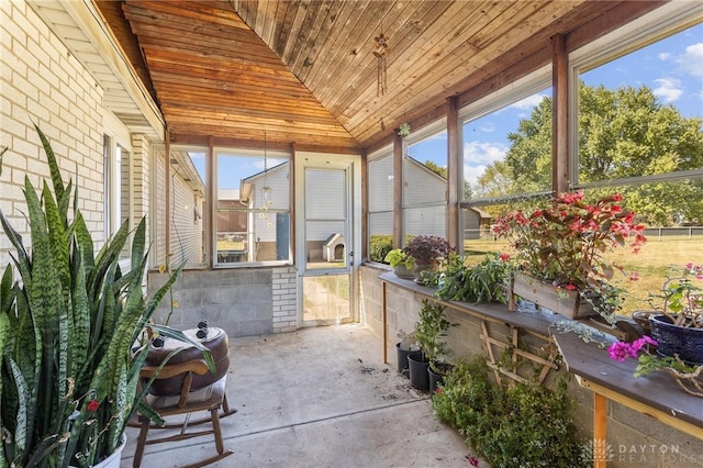 sunroom with a healthy amount of sunlight, wooden ceiling, and concrete flooring