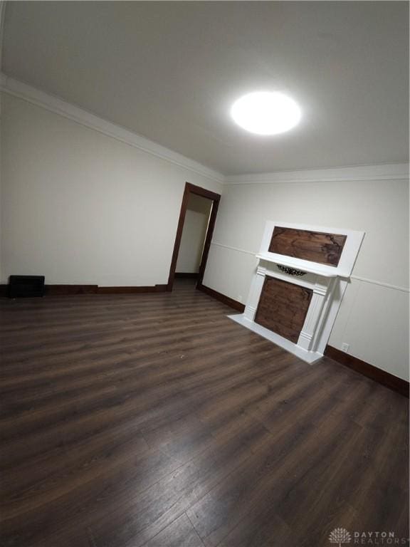 unfurnished living room featuring crown molding, baseboards, and dark wood finished floors