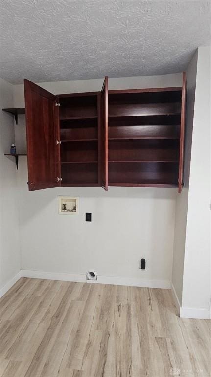 washroom with light wood-style flooring, laundry area, baseboards, and hookup for a washing machine