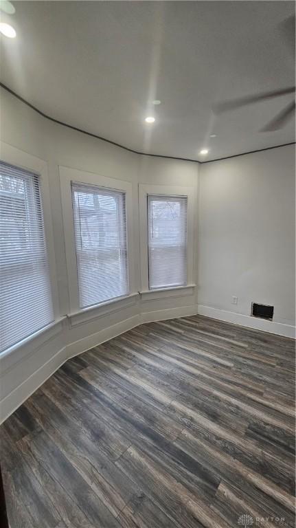 spare room featuring dark wood-type flooring, baseboards, and recessed lighting