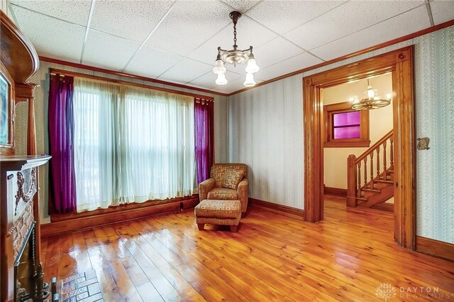 322 Hickory St, Dayton, OH 45410 - unfurnished room with light wood-type flooring, a drop ceiling, crown molding, a chandelier, and stairs