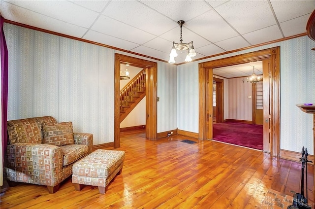 322 Hickory St, Dayton, OH 45410 - sitting room featuring stairway, wood-type flooring, an inviting chandelier, and wallpapered walls