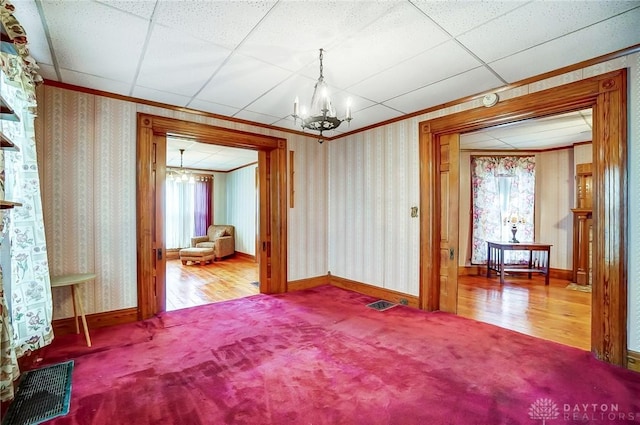 322 Hickory St, Dayton, OH 45410 - carpeted empty room with visible vents, wallpapered walls, and an inviting chandelier