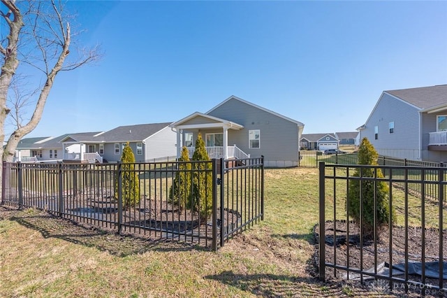 back of house featuring a yard, a residential view, and a fenced backyard
