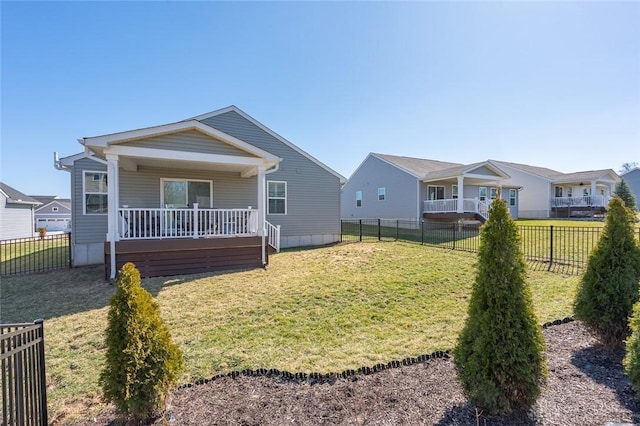 rear view of house featuring a lawn and a fenced backyard