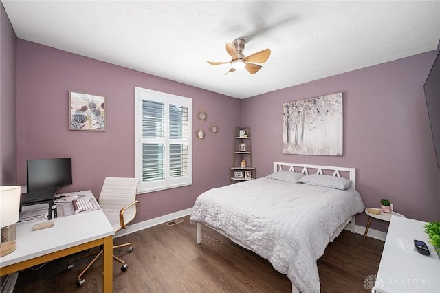 bedroom with ceiling fan, baseboards, and dark wood-style flooring