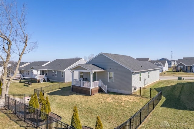 back of property featuring a residential view, a lawn, and a fenced backyard