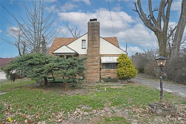 view of property exterior with a lawn and a chimney