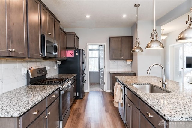 2012 Prestwick Bnd, Miamisburg, OH 45342 - kitchen featuring a sink, wood finished floors, stainless steel appliances, dark brown cabinetry, and light stone countertops