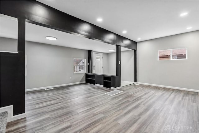 basement featuring recessed lighting, baseboards, and wood finished floors