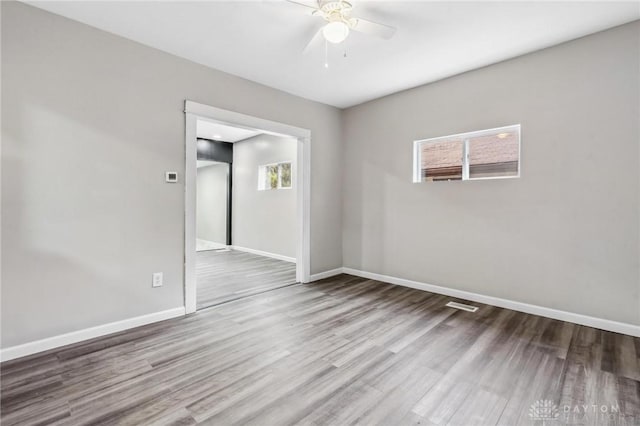 spare room with wood finished floors, baseboards, and ceiling fan