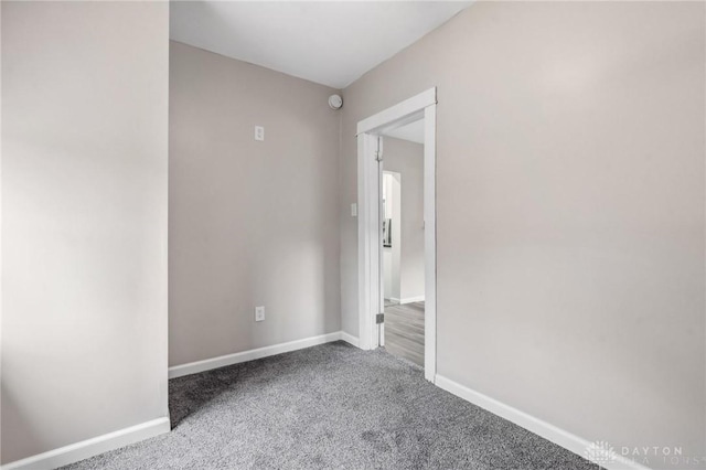 carpeted spare room featuring baseboards