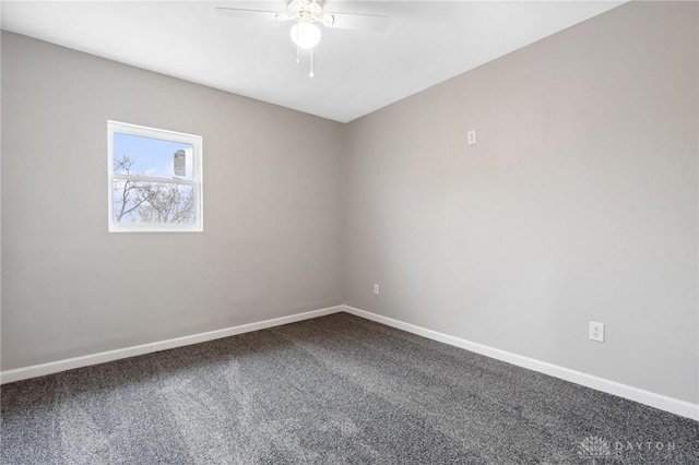 spare room featuring dark colored carpet, baseboards, and a ceiling fan