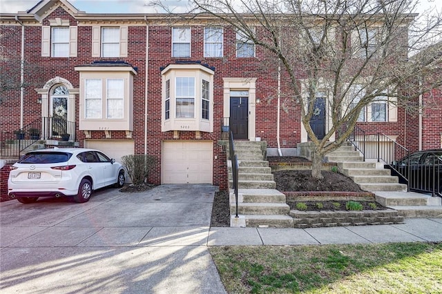 view of property with brick siding, driveway, and a garage