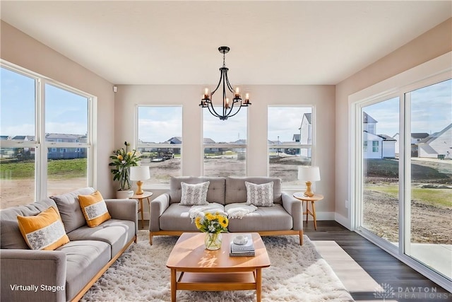 sunroom / solarium featuring a chandelier