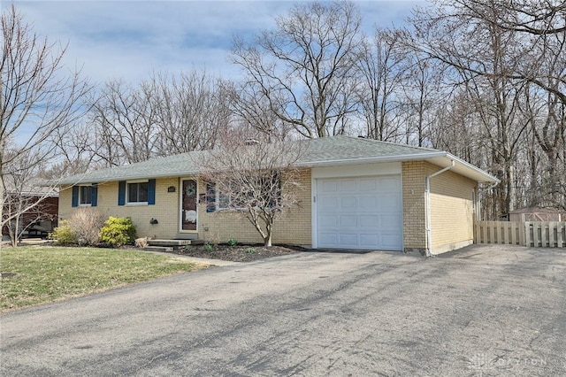 single story home with brick siding, driveway, a garage, and fence