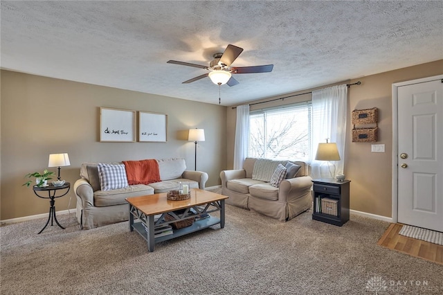 living room with baseboards, carpet flooring, a textured ceiling, and a ceiling fan