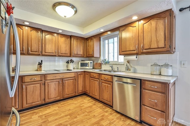 kitchen with brown cabinets, appliances with stainless steel finishes, and a sink